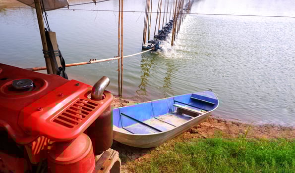 Motor engine with boat and aerator multiple turbine wheels on water surface for increase oxygen in shrimp pond and natural farm background photo
