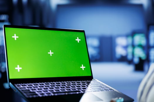 Admin in cloud computing business uses mockup laptop to prevent server machines overload. Expert between rackmounts using green screen device to enable enough network bandwidth for smooth operations photo