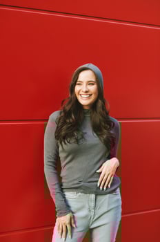 Outdoor portrait of young pretty woman posing on red background, wearing khaki hoodie photo