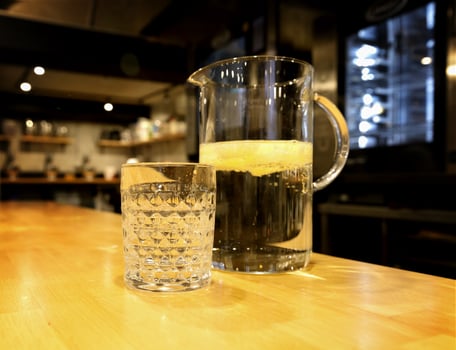 glass carafe with refreshing lemonade and glass glass stand on the table. selective focus.High quality photo