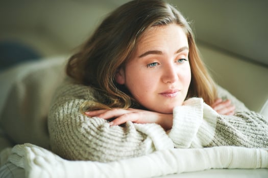 Young girl lying on couch, looking nowhere, sad emotions photo