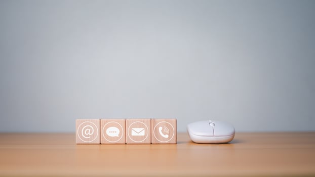 Website page contact us or email marketing concept, customer support hotline, contact us, wooden block printed communication symbol with mouse, email icons, phone, address, chat message. photo