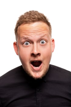 Vertical shot of stupefied stunned shocked young male keeps mouth widely opened, being surprised and very emotional, expresses great surprisment. photo