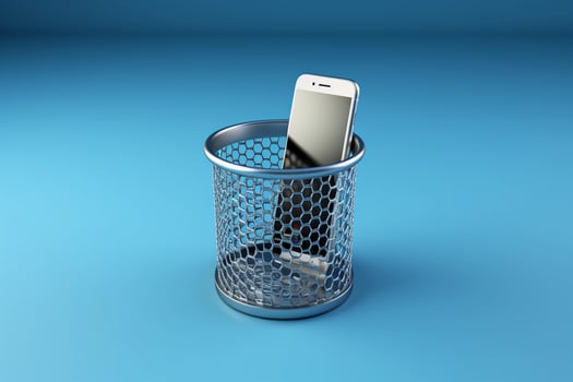 AI generated Smartphone thrown in the wastebasket on blue background. The concept of digital detox. AI generated. photo