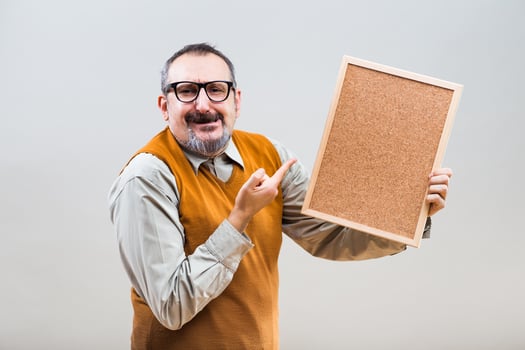 Nerdy businessman is showing empty cork board photo