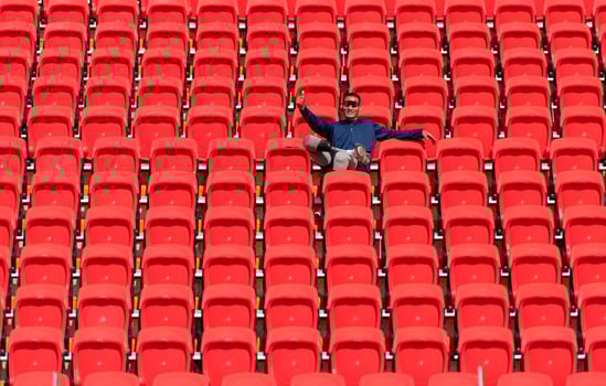 Disabled athletes in a blue shirt sitting on the red seats at the stadium, Prepare for running training. photo