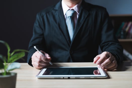 businessman using tablet computer and taking notes in planning. which is payment online, sits on the chair in the living room at home on a laptop. The concept of finance and online shopping. photo