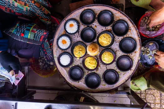 Vietnamese Street Food in Da Lat city, Vietnam - Banh can on the warm ember stove kitchen. Food and travel concept. photo