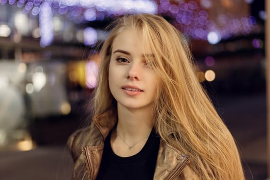 woman smiling in the night against evening lights bokeh photo