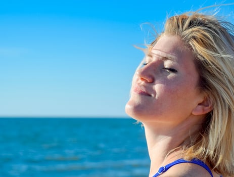 The girl relaxes by the sea under the breath of the sea breeze. Happiness by the sea. Relaxing emotions. photo