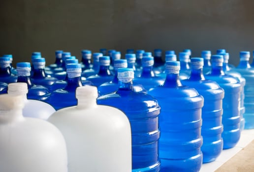 plastic big bottles or white and blue gallons of purified drinking water inside the production line. Water drink factory photo