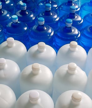 Top view of plastic big bottles or white and blue gallons of purified drinking water inside the production line. Water drink factory photo