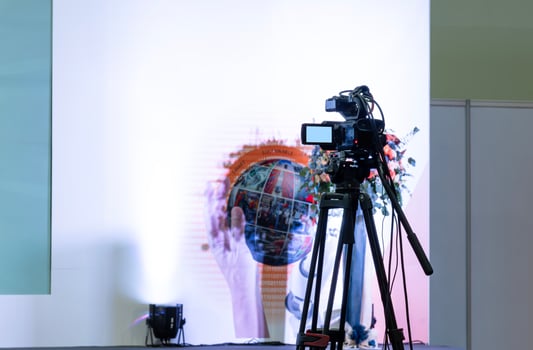 Back view video camera on tripod look to stage at business presentation exhibition photo