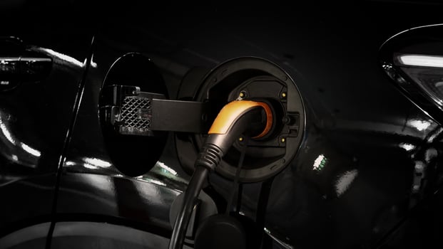 Electric Vehicle car or EV Car parking at charging station and plugged power cable supply. Charge power to EV or hybrid car battery. Green energy and eco power of World future transportation. EV power photo