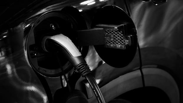 Electric Vehicle car or EV Car parking at charging station and plugged power cable supply. Charge power to EV or hybrid car battery. Green energy and eco power of World future transportation. EV power photo