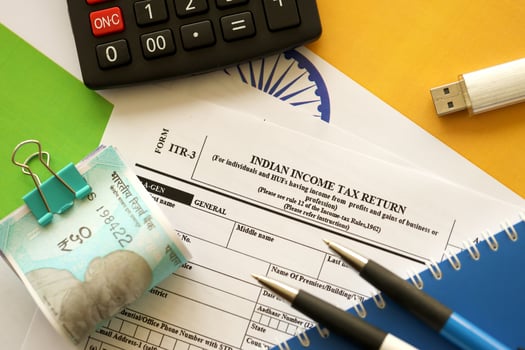 KYIV, UKRAINE - MAY 4, 2022 Indian income tax return blank form with pen and indian rupees bills photo