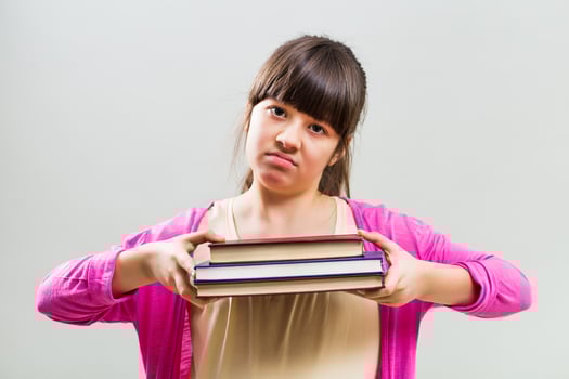 Angry little girl with books photo