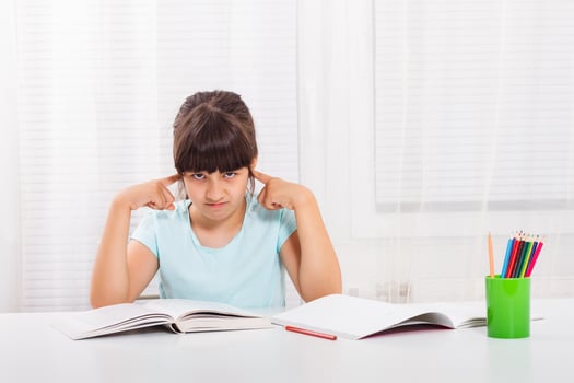 Angry little girl must stay at home and do her homework,but she would rather play outside. photo