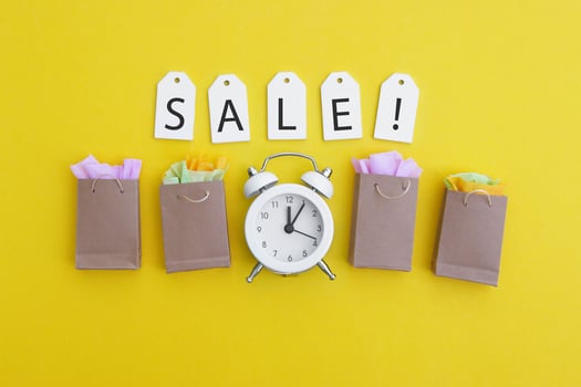 Labels with the words SALE with paper bags, an vintage white clock on a bright yellow background. photo