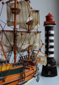 Diorama Of Wooden Model Masted Sailing Ship And Model Of Beacon Isolated On White Background photo