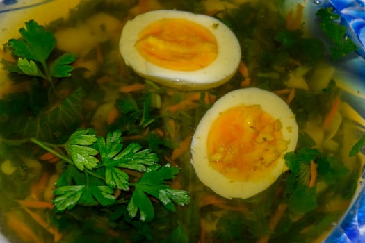 Soup with boiled egg and parsley photo