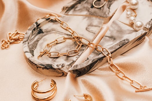 Women's jewelry, gold chain, trendy jewelry on a silk background. photo