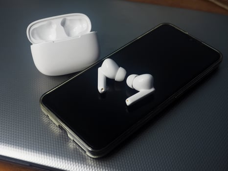 white earbuds and smart phone connect together photo