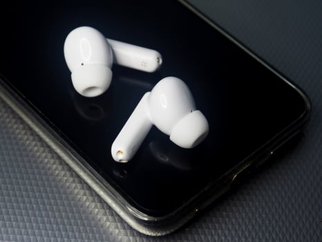 white earbuds and smart phone connect together photo