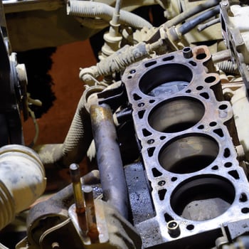 The cylinder block of the four-cylinder engine. Disassembled motor vehicle for repair. Parts in engine oil. Car engine repair in the service photo