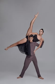 Two athletic modern ballet dancers are posing against a gray studio background. photo