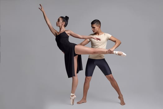 Two athletic modern ballet dancers are posing against a gray studio background. photo