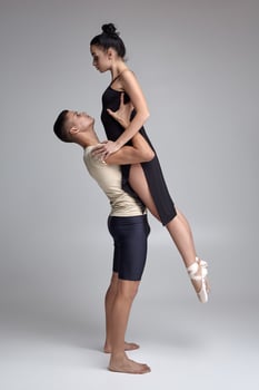 Two athletic modern ballet dancers are posing against a gray studio background. photo
