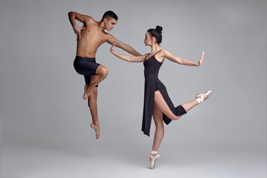 Two athletic modern ballet dancers are posing against a gray studio background. photo