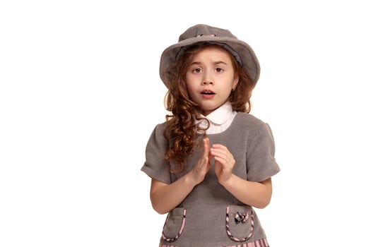 Studio shot of a lovely little kid with a long, curly hair posing isolated on white background. photo