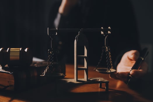 law books and scales of justice on desk in library of law firm. jurisprudence legal education concept. photo