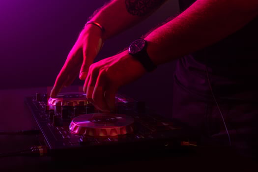 Dj mixing on turntables with color light effects. Soft focus on hand. Close-up. photo