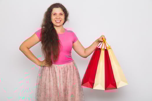 Portrait of young happy smiling woman with shopping bags, over white background. Purchase, sale and people concept photo