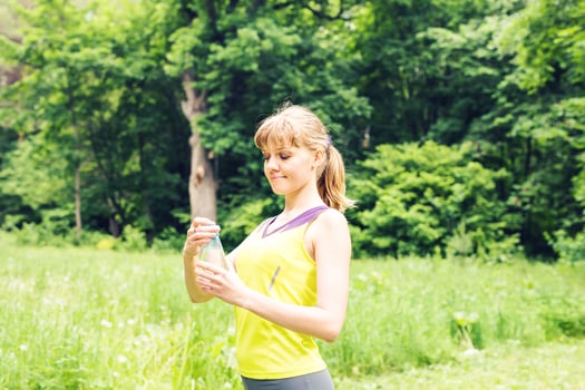 Fit woman outdoors holding a bottle of water photo