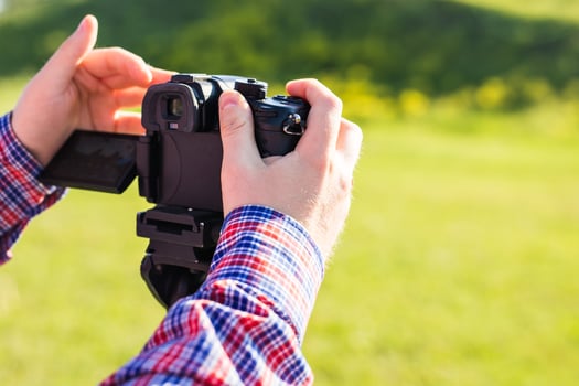 Professional photographer adjusts the camera before shooting, hands photo
