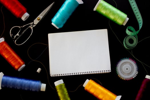Sewing supplies and notepad for notes on a black background. Place for text. photo
