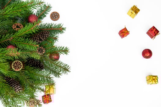 Branches of a Christmas tree and red and yellow gift boxes and balls on a white background. Christmas background with copyspace. photo