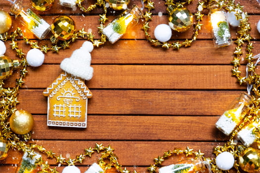 Tiny gingerbread house on wooden background with Christmas decor layout and copy space. Gift for New Year, Christmas. Building, project, moving to new house, mortgage, rent and purchase real estate photo