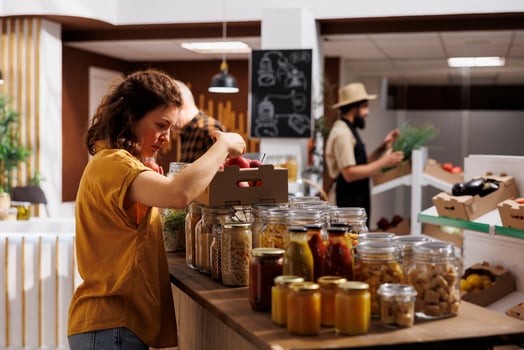 Healthy living woman in zero waste shop looking to buy freshly handpicked apples and other fruits. Customer shopping for chemicals free groceries in local neighborhood store photo