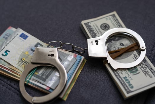 Police handcuffs lie on many dollar bills isolated on black background. Crime. justice and money. Concept of crime and corruption with handcuffs. photo