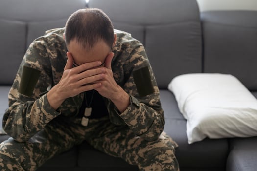 Nervous male military suffering depression, sitting alone at home, PTSD concept photo
