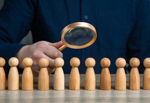 A man studies people through a magnifying glass. Sociology and marketing. Finding people and workers on the job. Uncover patterns, motivations, and influences that guide community behavior photo