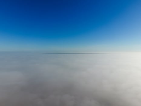 In the skies above the fog. Sunrise over the fog. Clouds near the ground photo