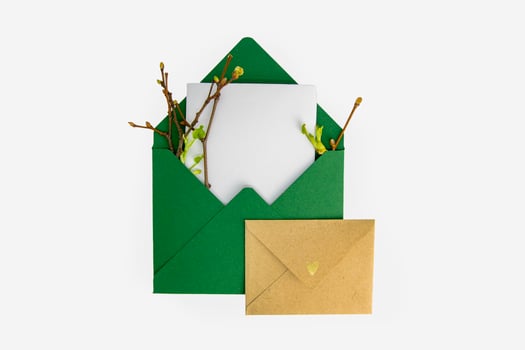 Mockup invitation, blank greeting card with spring greens. Flat lay, top view. photo