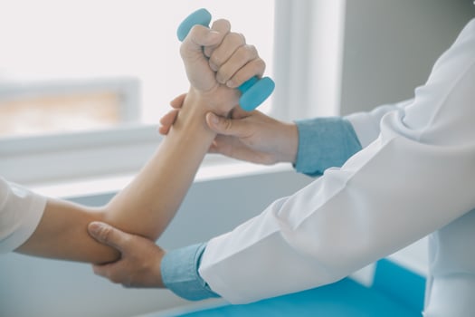 Doctor or physical therapist examines back pain and spinal area to give advice within the rehabilitation center. photo
