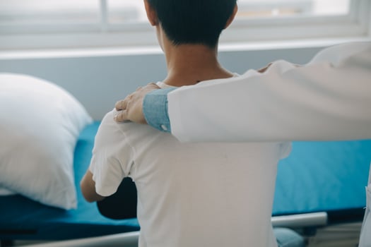 Doctor or physical therapist examines back pain and spinal area to give advice within the rehabilitation center. photo